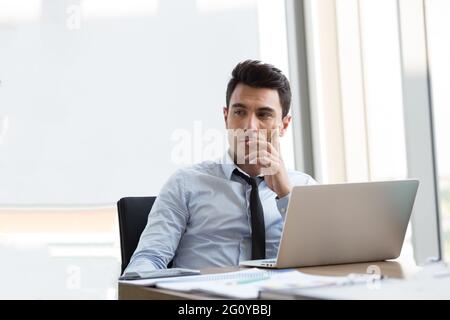 Confident professional businessman executive thinks developing a new idea and planning new project Stock Photo