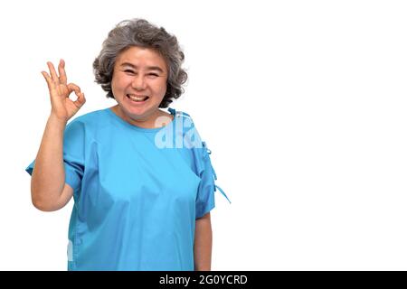 Portrait of happy senior asian woman patient showing hand ok and looking at camera isolated on white background, Older female feeling positive and enj