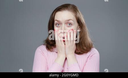 Photo of amazed woman in pink turtleneck, close-up Stock Photo