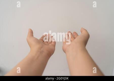 two open empty female hands with palms up, holding something, isolated on white background. Selective focus. Stock Photo