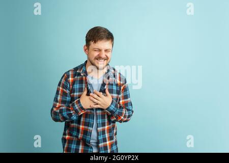 Funny young Caucasian bearded man in casual clothes isolated on light blue background. Having fun. Stock Photo