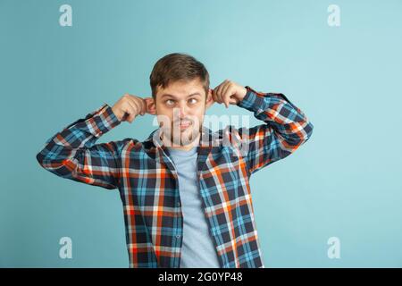 Funny young Caucasian bearded man in casual clothes isolated on light blue background. Having fun. Stock Photo