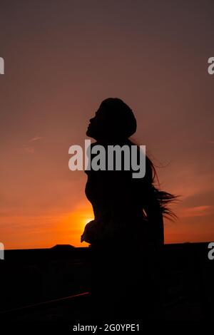 Photo of silhouette adult woman in profile on twilight background. Lonely  woman standing alone moments sunset. Style abstract shadows. Let's Stay  Toge Stock Photo - Alamy