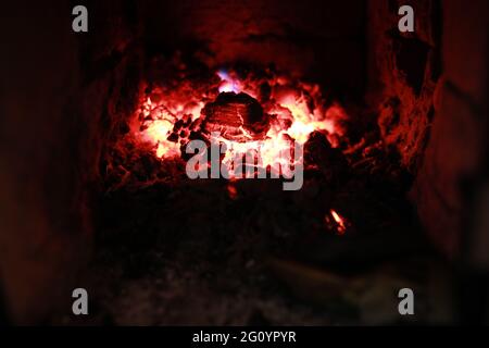 heated stove in the house with red coals and fire Stock Photo