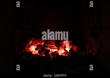 heated stove in the house with red coals and fire Stock Photo