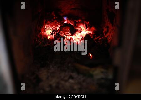 heated stove in the house with red coals and fire Stock Photo
