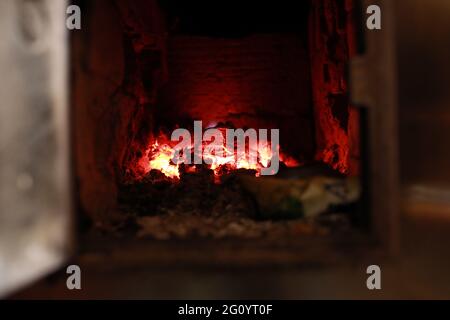 heated stove in the house with red coals and fire Stock Photo
