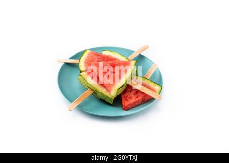 Watermelon slices popsicles on blue plate isolated on white background Stock Photo