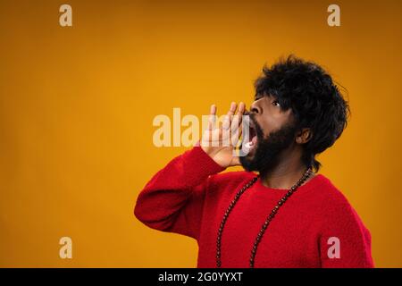 Screaming african american guy against yellow background Stock Photo