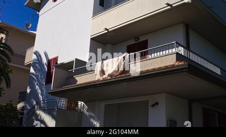 A quilted blanket spread out on the balcony to dry (Marche, Italy, Europe) Stock Photo