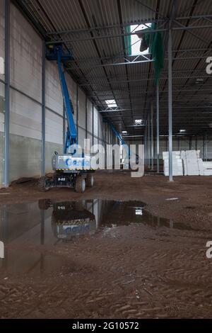 VENLO, NETHERLANDS - Feb 01, 2018: Three aerial platforms in a warehouse that is under construction. The platforms are near the roof. Stock Photo