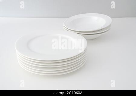 A set of clean white dishes on a clean background. Minimalist tableware Stock Photo