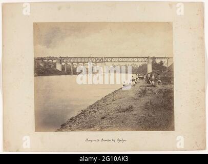 Bridge over the Brantas at Djadjar; State railways on Java. The construction of the bridge over the Brantas at Djadjar. In the foreground workers on the riverbank. Part of a group of 62 photos in a box with the inscription 'State Railways on Java' from 1888. Stock Photo