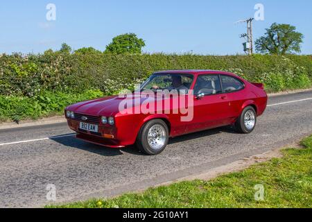 1984 80s eighties red petrol Ford Capri Laser 2dr saloon, en-route to Capesthorne Hall classic May car show, Cheshire, UK Stock Photo