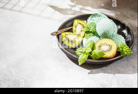 Homemade kiwi popsicles, with mint leaves on a concrete background. Selective focus, copy space Stock Photo