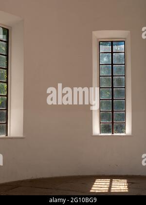 Light falling through the beautiful wooden high french window over the cracked rocky floor of an old chapel. Beautiful play of light and shade. Stock Photo