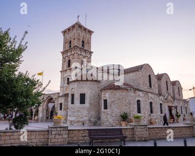 Ancient stone saint Lazarus church at the central square of Larnaca old town in Cyprus. People walking around, bench at the front. Historic heritage. Stock Photo