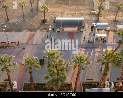 Top aerial view overlooking the central bus stop at Finikoudes Palm tree promenade and volleyball court at the beach near Mediterranean sea in Larnaca Stock Photo