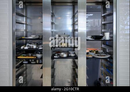 Dirty dishware and food waste on tray keeping in storage compartment Stock Photo