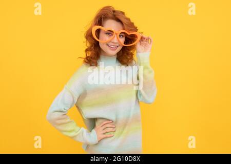 happy redhead woman wear funny party glasses on yellow background, celebration Stock Photo