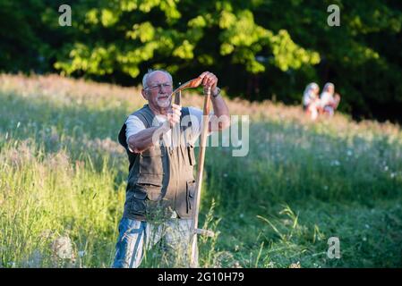 Prague, Czech Republic. 04th June, 2021. A man sharpens the scythe. Once per year flower meadow in Stromovka park, one of the biggest park in the Prague, is manually mown in order to save folk tradition. Credit: SOPA Images Limited/Alamy Live News Stock Photo