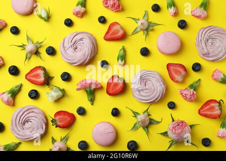 Concept of tasty macaroons and marshmallows on yellow background Stock Photo