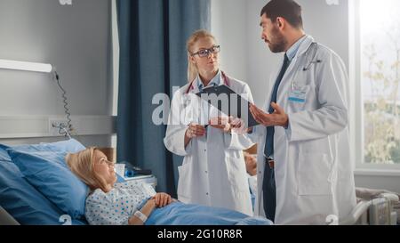 Hospital Ward: Male and Feamle Professional Caucasian Doctors Talk with a Patient, Give Health Care Advice, Recommend Treatment Plan. Modern Clinic Stock Photo