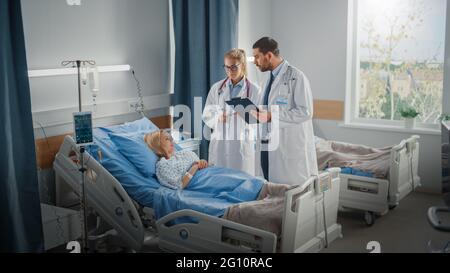 Hospital Ward: Male and Feamle Professional Caucasian Doctors Talk with a Patient, Give Health Care Advice, Recommend Treatment Plan. Modern Clinic Stock Photo