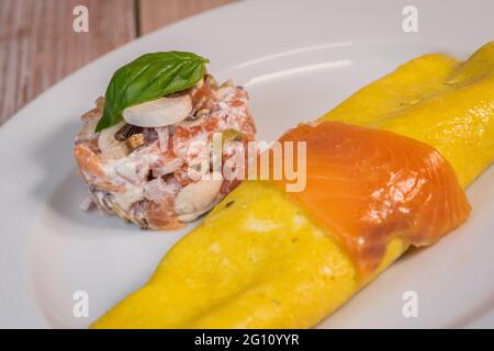 Omelette with salmon and tomatoes, served on plate, traditional Norwegian dish Stock Photo