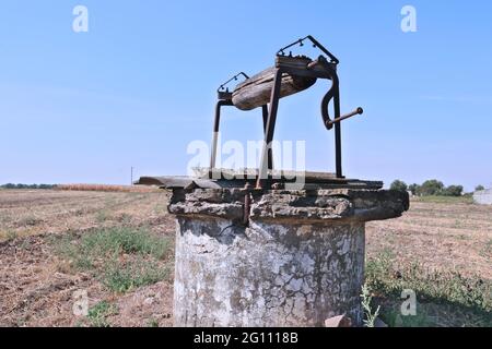 Old abandoned water well in the field Stock Photo