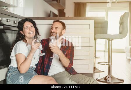 Millennial couple toast their anniversary with a glass of wine - love and happines concept - warm filter on background Stock Photo