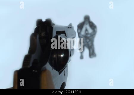 Revolver is aimed at the target. An enemy soldier is depicted on the target Stock Photo