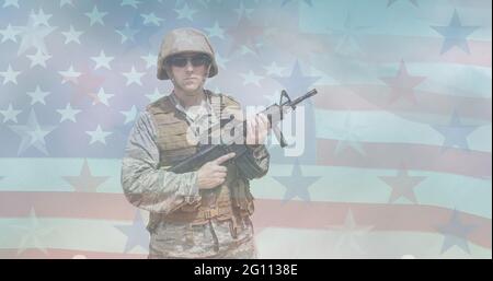 Composition of male soldier holding machine gun over american flag Stock Photo