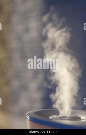 Humidifier spreading steam with white brick wall background. Loft style ...