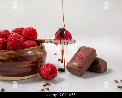 Dark handmade chocolate with raspberries and syrup Stock Photo