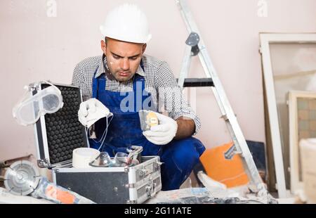 worker builder is carefully looking Stock Photo