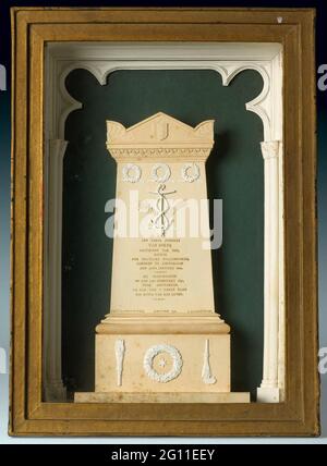 Model of the Cenotaphium in honor of J. C. J. van Speyk in the Nieuwe Kerk in Amsterdam. Cardboard monument with Amsterdam coat of arms, underneath three wreaths, an anchor surrounded by one in his tail biting hose with two palm branches and an ordinary cross, inscription in gold print. On foot a star surrounded by a wreath flanked by two torches, the right upside down. On a green background and light blue bottom, the sides and top in the form of pillars and vault ornament. In gold plated coffin behind glass. Inscription. Signed: J.t.f. Steenbergen Fecit Stock Photo