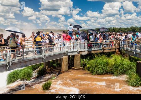 IGUAZU, ARGENTINA - FEB 6, 2015: Tourists admire Iguacu (Iguazu) falls on a border of Brazil and Argentina Stock Photo
