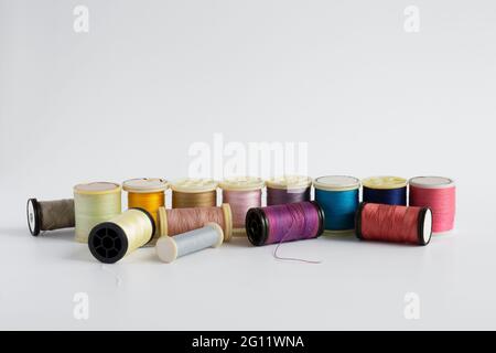 Spools of thread on a white background lined up in color Stock Photo