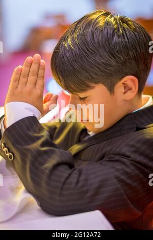 Child boy praying in a Catholic church (no release available) Stock Photo