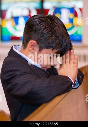 Child boy praying in a Catholic church (no release available) Stock Photo