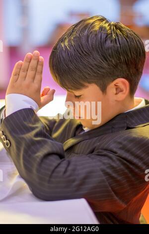 Child boy praying in a Catholic church (no release available) Stock Photo