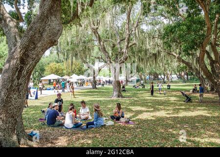 Miami Florida,Legion Park Farmers Market day,family families parent parents child children,friends circle picnic live oak trees Spanish moss,visitors Stock Photo