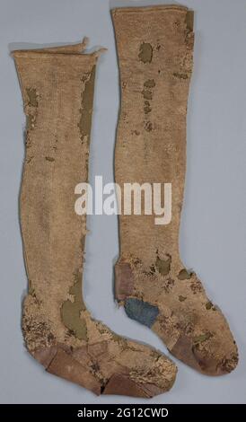 Knickous, light brown, the edge is knitted in predealous stitch and a decorative seam runs from the edge to the heel. Knickous, light brown, the edge is knitted in predealous stitch and a decorative seam runs from the edge to the heel. The rest medium-knitted by hand in tricot stitch. This stocking was worn for a long time. First you have tried to stop the holes with coarse light brown, brown and dark brown wires. When this no longer succeeded, five repair pieces have been sewn. Of these, three are woven in plain / flat binding and one in twill binding and a piece of felt is used. These pieces Stock Photo