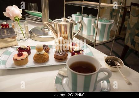 A fine table serving of afternoon tea with cakes, at Claridges Bar, Claridges Hotel, Mayfair London UK Stock Photo