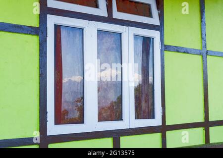 Beautiful reflection of snowy Mount Kanchenjungha on glass window , wet with dew drops. Image of Himalayan mountain range, Sikkim, India. Stock Photo