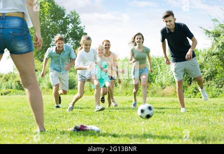 Mother and father with four kids running in park Stock Photo