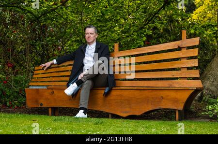 Fergus Linehan, Festival Director, at Edinburgh International Festival launch sitting on bench in Royal Botanic Garden, Scotland, UK Stock Photo