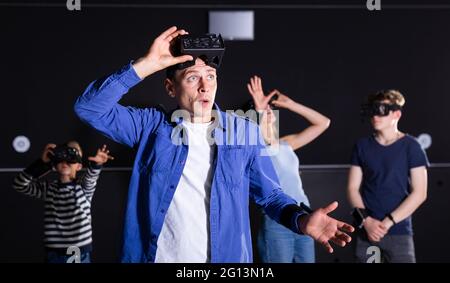 Portrait of a surprised young man who took off his virtual reality glasses Stock Photo