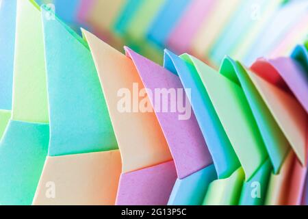 Origami background, abstract parametric structure made of colorful paper sheets, close up photo with selective soft focus Stock Photo